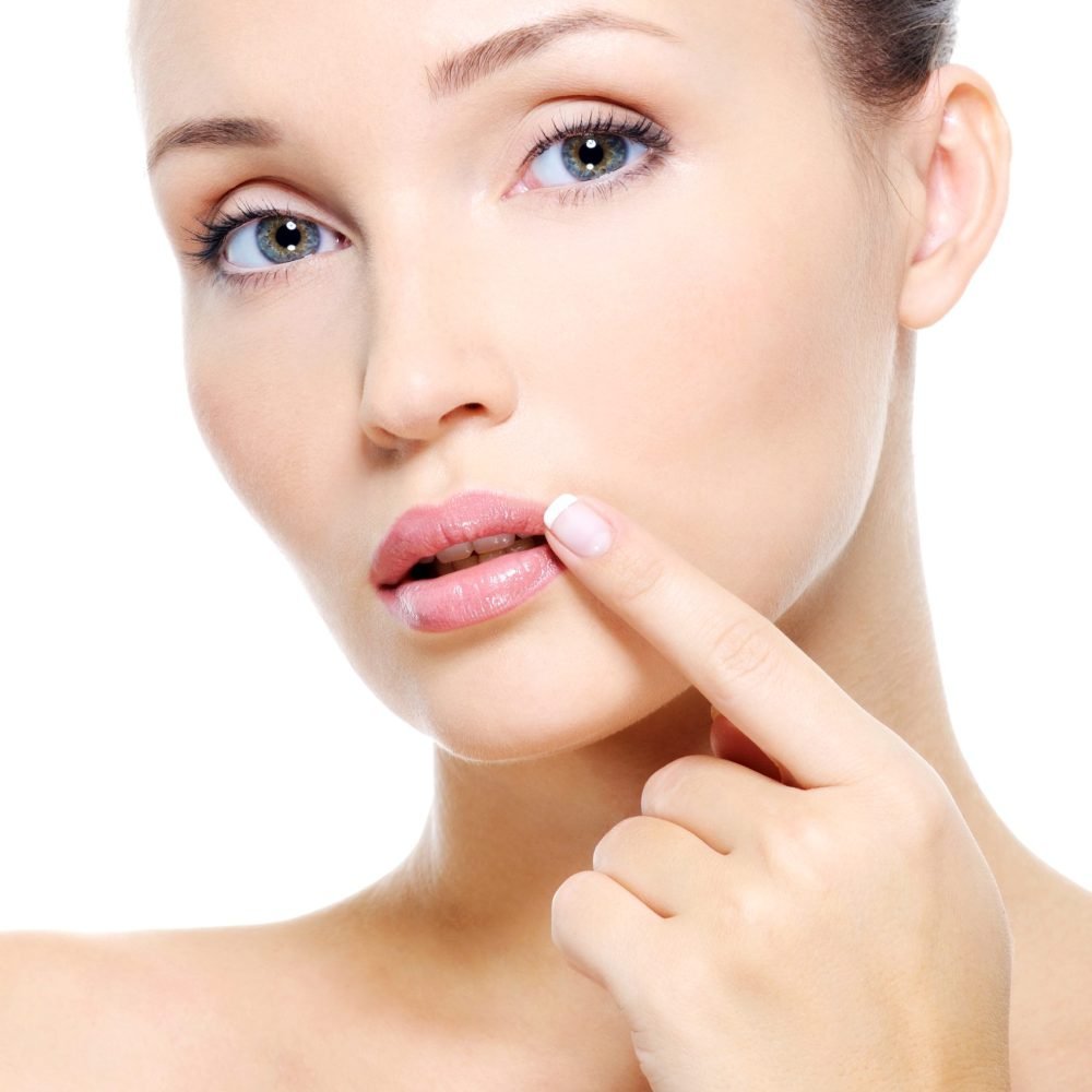 Face of a Pretty young woman touch to  lips - on white background