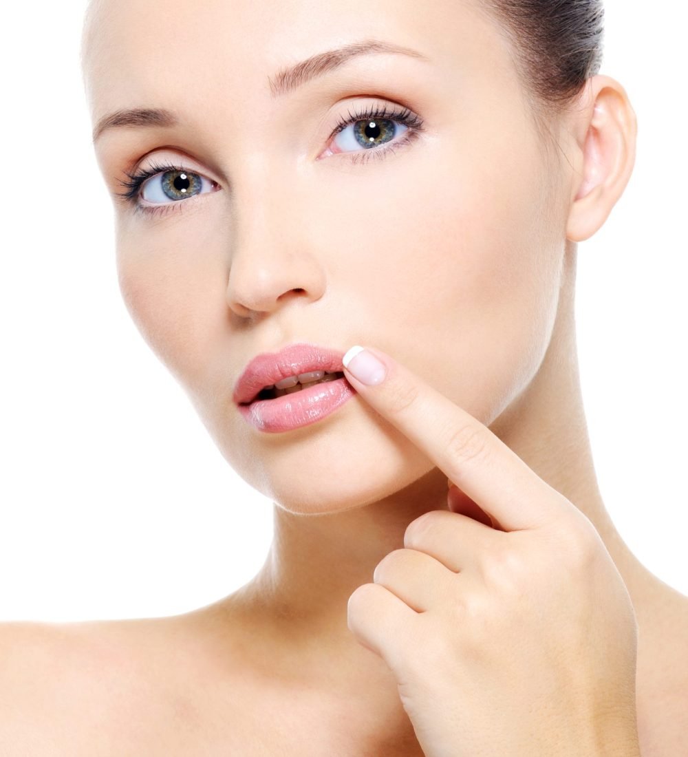 Face of a Pretty young woman touch to  lips - on white background